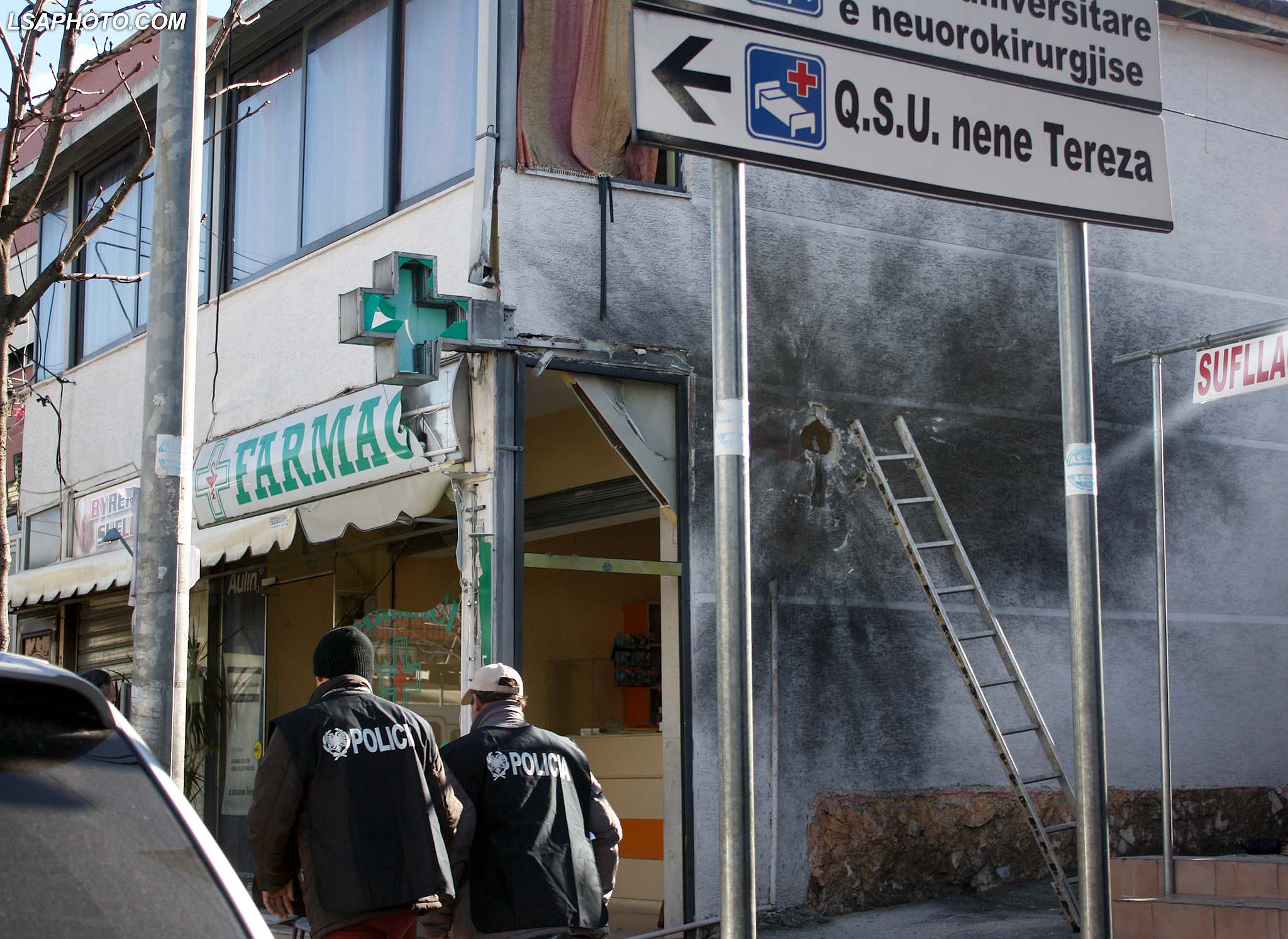 Forca te policise, duke vezhguar farmacine e babait te ministrit te brendshëm Saimir Tahiri, pasi eshte demtuar nga nje shperthim eksplozivi mbremjen e djeshme prane spitalit numer 5, ne Tirane. /r/n/r/nPolice officers investigate a drug store belonging to Interior Minister Saimir Tahiri’s father damaged by an explosion overnight in Tirana, Albania, Tuesday, Feb. 10, 2015. Another explosion rocked the apartment of a top police officer while anti-mine experts blasted with remote control two TNT explosive ingots found downtown capital.