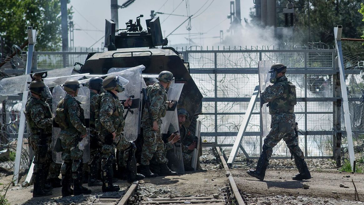 Macedonian police officers stand guard and protect themselves from stones thrown by migrants and refugees during clashes at the Greek-Macedonian border near Gevgelija on April 10, 2016.
Dozens of people were hurt on Sunday when police fired tear gas on a group of migrants as they tried to break through a fence on the Greece-Macedonia border, the medical charity Doctors without Borders (MSF) said. A Macedonian police source said three officers were also injured by stones thrown by the protesting migrants. The incident took place near the Idomeni border crossing in northern Greece, a flashpoint where more than 11,200 people have been stranded after Balkan states closed off the migrant route in mid-February.
 / AFP PHOTO / Robert ATANASOVSKI
