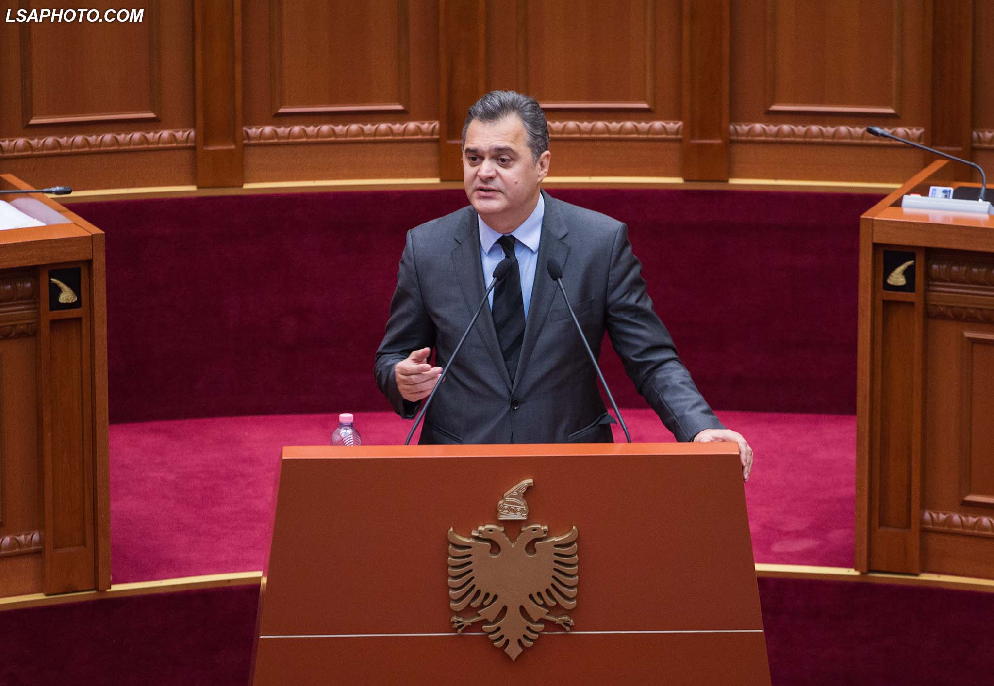 Deputeti i PS, Ben Blushi, duke folur gjate nje seance parlamentare, ku eshte debatuar mes opozites dhe maxhorances ne lidhje me ikjen masive te shqiptareve nga vendi.	/r/n/r/nLawmaker, Ben Blushi, speaks during a parliamentary session.