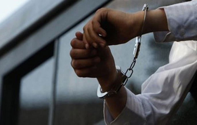 An ultra-Orthodox Jewish boy with handcuffs looks out of the window of a bus, carrying some of 80 Ashkenazi parents who were to report to jail for defying the Supreme Court ruling, during a rally in Jerusalem June 17, 2010. Tens of thousands of ultra-Orthodox Jews protested in Israel on Thursday against the court order to desegregate a religious school and force Jewish girls of European and Middle Eastern descent to study together. The boy was wearing the handcuffs in solidarity with the parents on the bus. REUTERS/Ronen Zvulun (JERUSALEM - Tags: POLITICS CIVIL UNREST RELIGION IMAGES OF THE DAY)