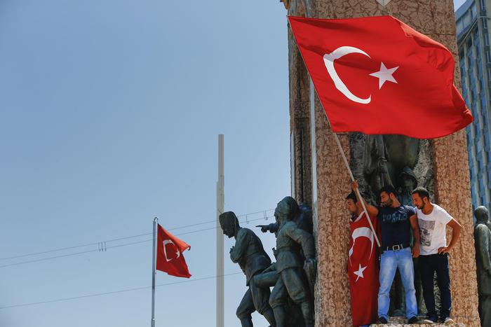 People protesting against the coup, wave a Turkish flag on top of the monument in Taksim square, Istanbul, Turkey, Saturday, July 16, 2016. Turkish President Recep Tayyip Erdogan told the nation Saturday that his government is in charge after a coup attempt brought a night of explosions, air battles and gunfire across the capital that left dozens dead. The state-run news agency said more than 750 soldiers have been detained across the country. (ANSA/AP Photo/Emrah Gurel) [CopyrightNotice: Copyright 2016 The Associated Press. All rights reserved. This material may not be published, broadcast, rewritten or redistribu]